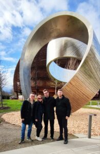 Data Science team from BitPeak next to CERN sculpture